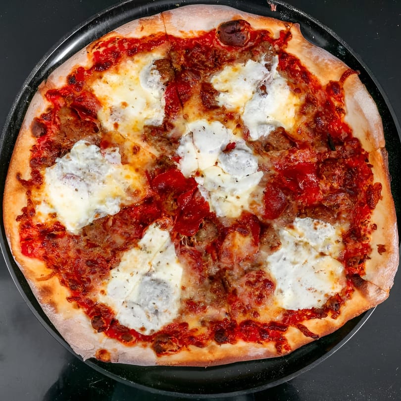 Bruno's Pizza with red sauce, melted mozzarella, dollops of ricotta, and crumbled sausage.